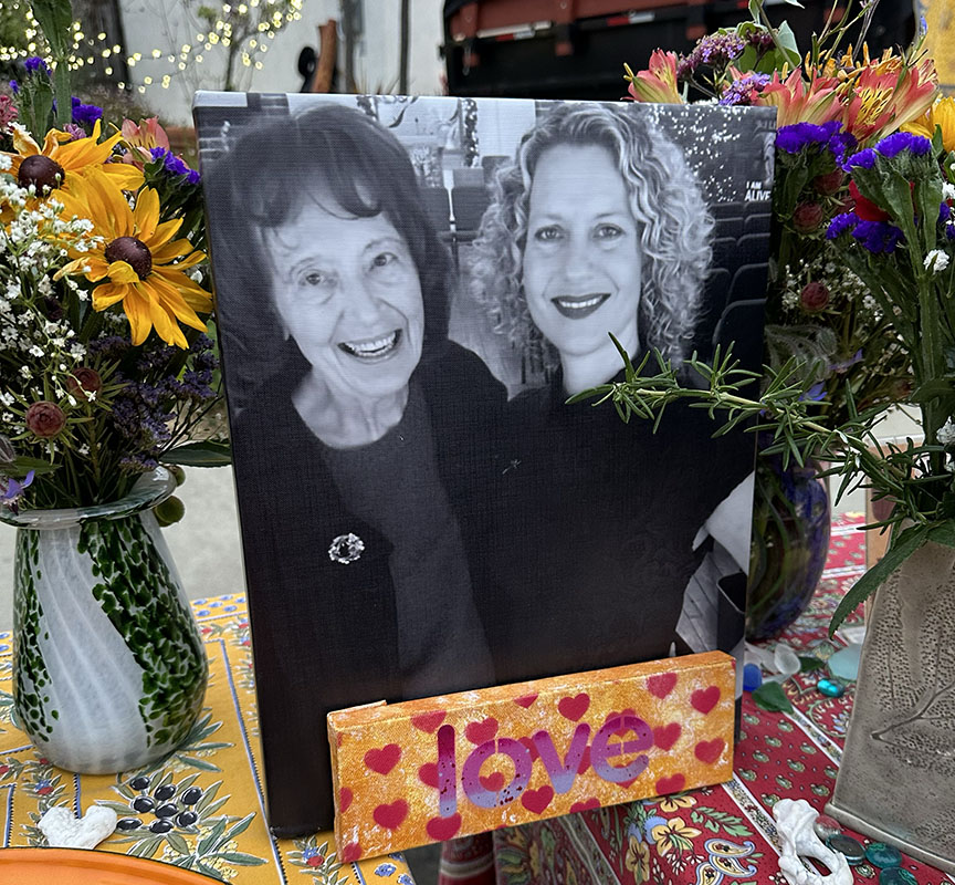 Picture of Carol Grimes and Kelley Grimes with flowers and a sign that says love